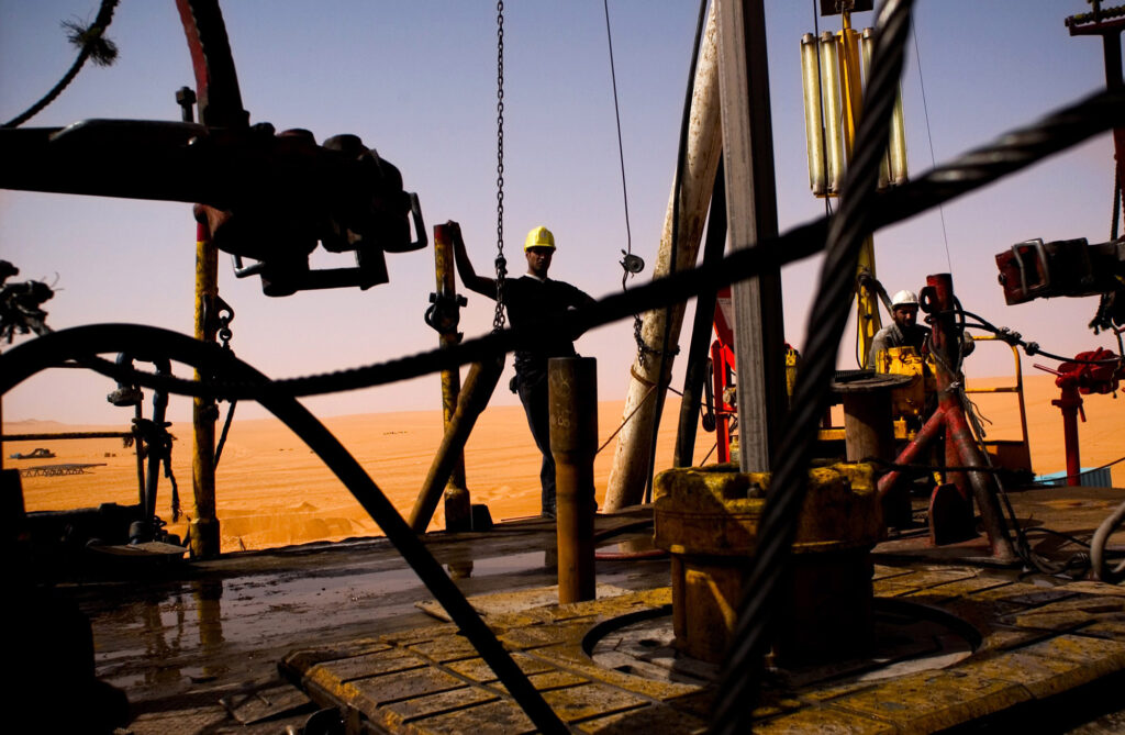 EL-SHARARA, LIBYA - JUNE 5:  A Repsol Oil Operations oil drilling rig pounds into the desert searching through thousands of feet for and oil reserve on June 5, 2004 in El-Sharara, Libya. With the lifting of US sanctions earlier this year, American oil companies, eager to find other avenues for oil exploration have begun negotiating with the Libyan government to return to its vast oil fields.  (Photo by Benjamin Lowy/Getty Images)